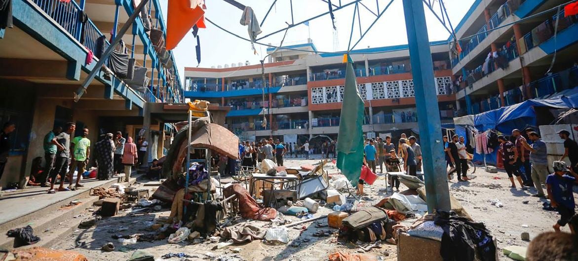 فلسطينيون وسط ركام مدرسة متضررة في قطاع غزة